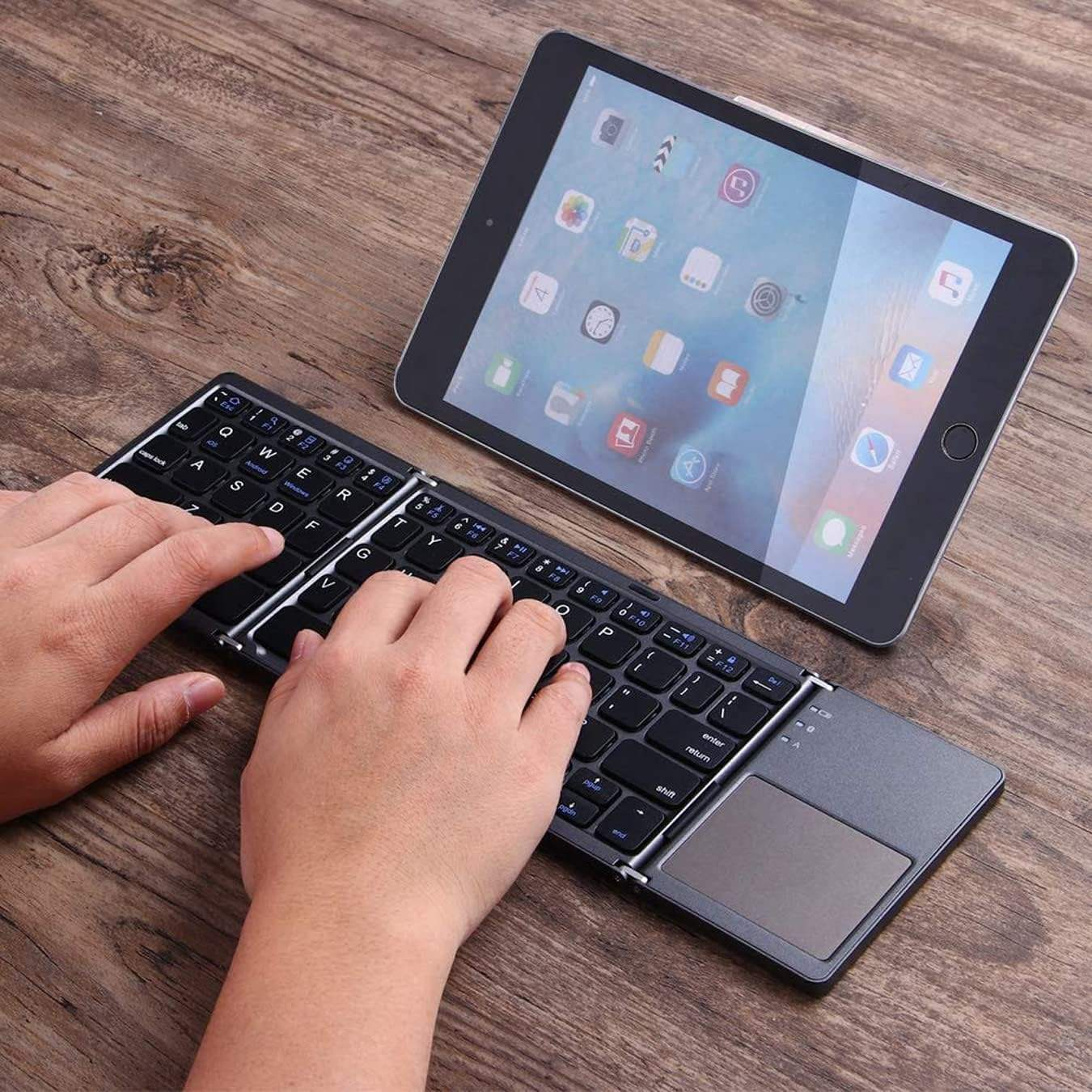 Tri-fold ultra-thin wireless Bluetooth keyboard for iPad, portable for business and office use, with touchpad.